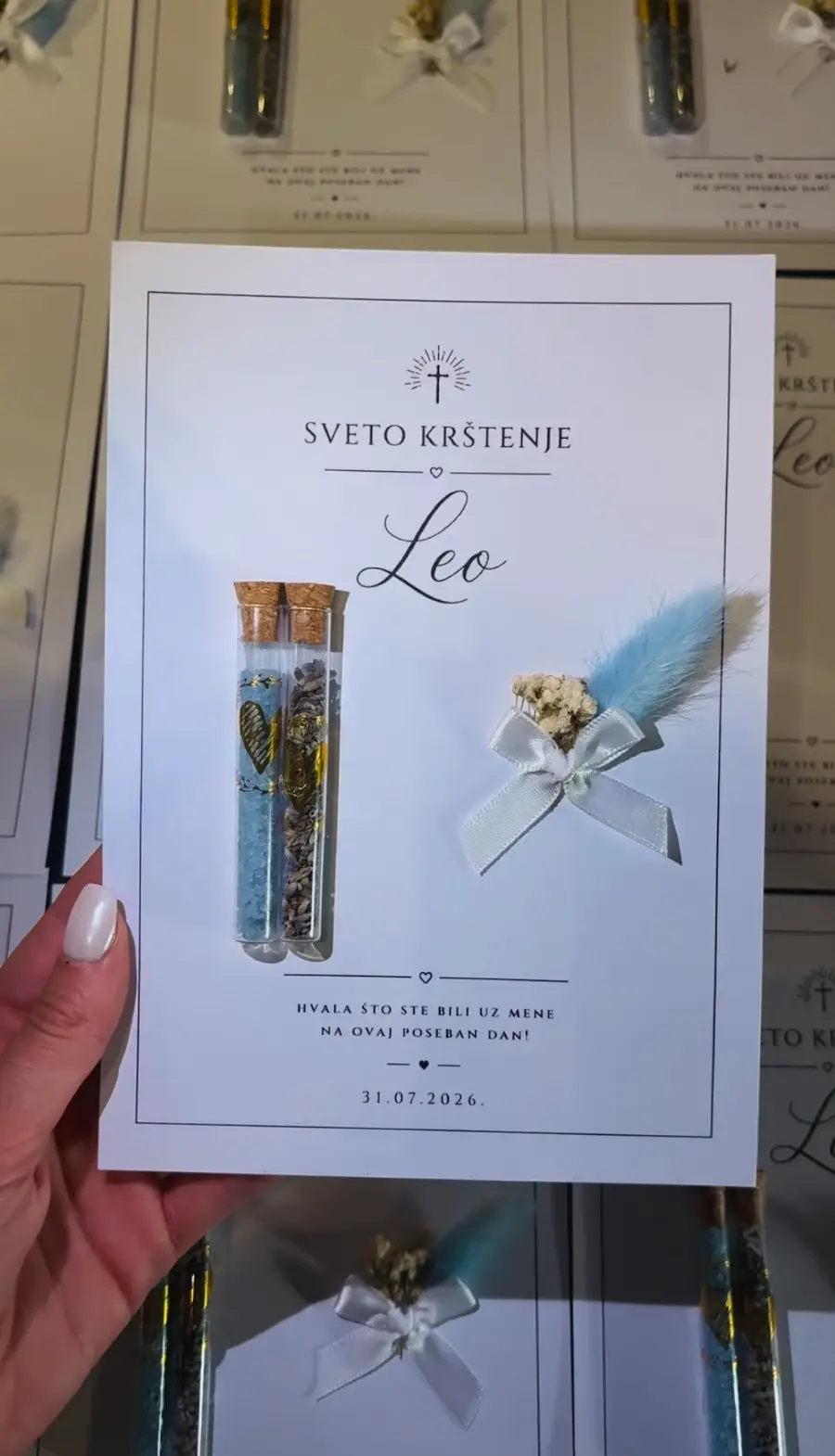 Weiße Karte mit Namen, Reagenzglas mit Trockenblumen und Reagenzglas mit blauem Kristallsalz