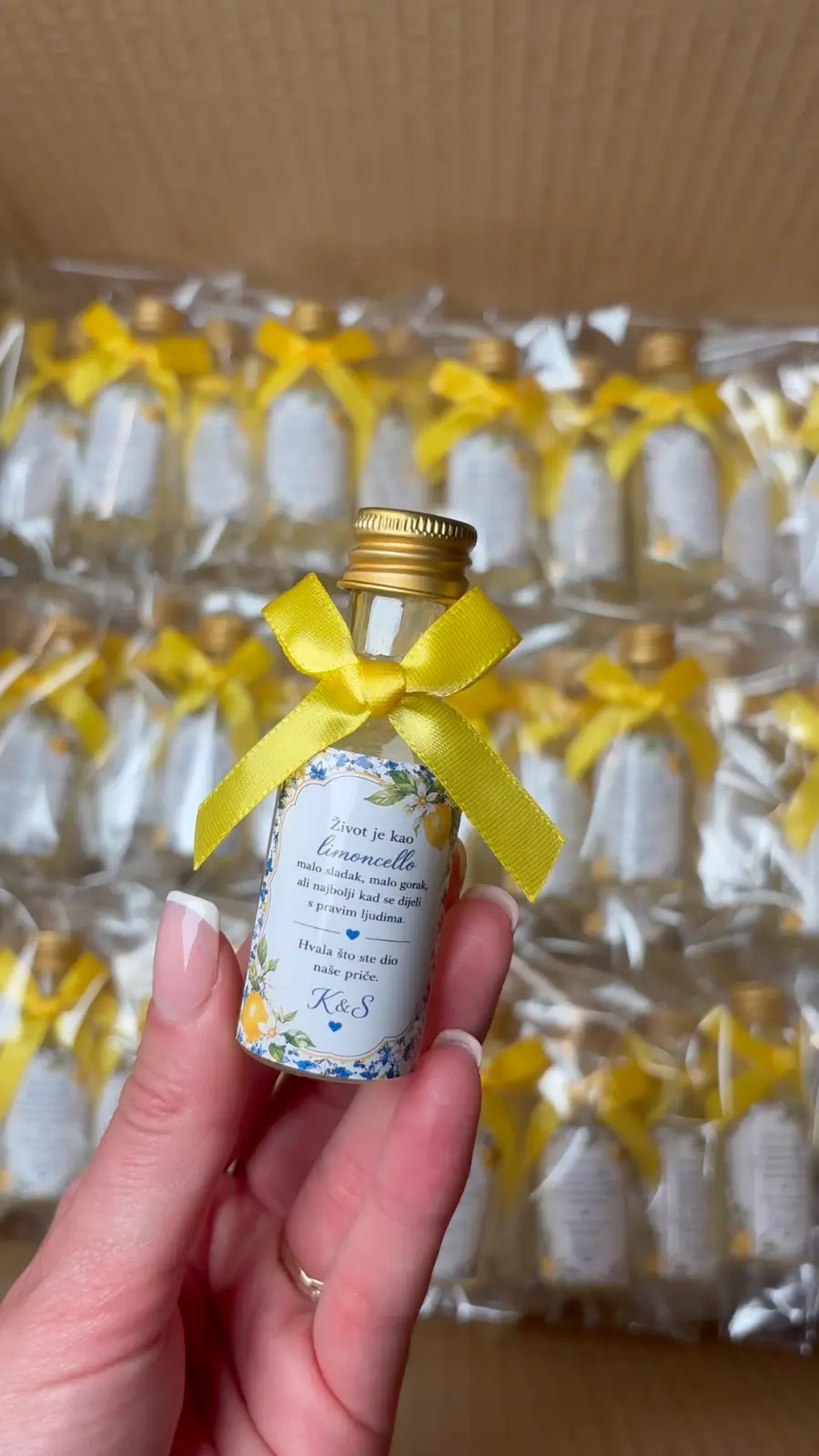 Bočica sa zlatnim čepom, žutom vrpcom i personaliziranom etiketom s limunima i inicijalima K&S