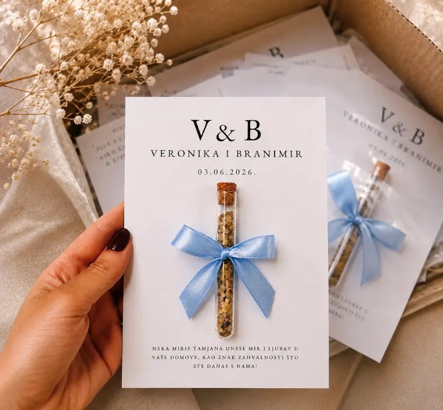 Bijela kartica s monogramom V & B, imenima Veronika i Branimir i epruvetom tamjana vezanom plavom vrpcom